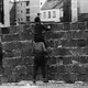 Children peer over the wall into the eastern part of the city